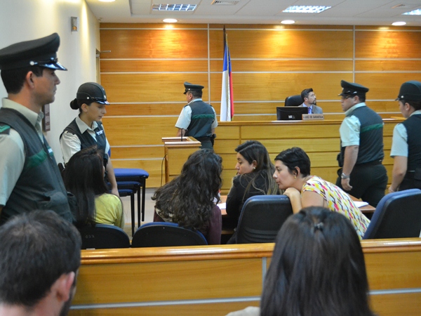 Las defensoras públicas (a la derecha) instruyen a sus representadas durante la audiencia de control de detención.