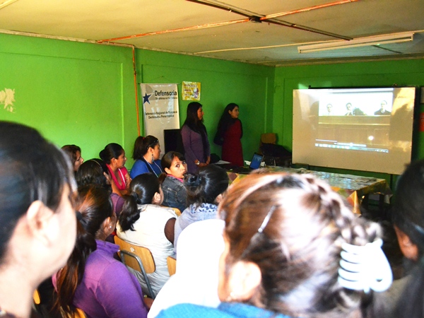 Las inmigrantes estuvieron atentos a la exhibición de un video educativo sobre el sistema penal en Chile.
