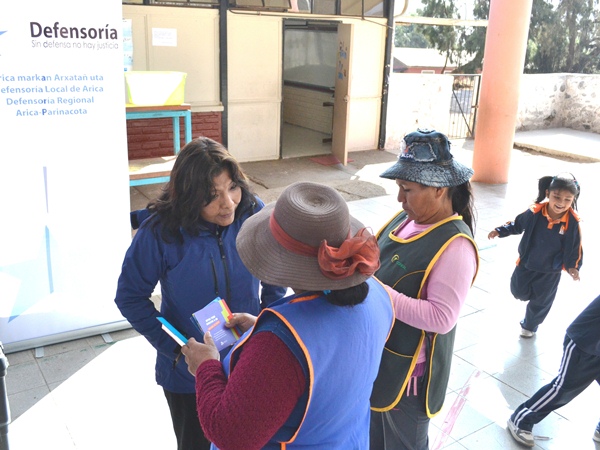 La facilitadora intercultural de la Defensoría conversa en aymara con pobladoras de Poconchile.