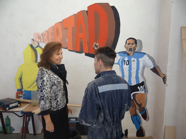 La Defensora Regional felicita a uno de los jóvenes que cumple sanción en el centro, por su trabajo en el taller de muralismo.