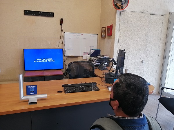 En el área de atención de público de la Defensoría Local de Valparaíso, un representado mira las cápsulas para conocer el sistema penal.