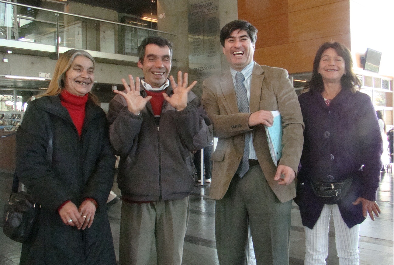 José Manuel Torres junto a su defensor público, Néstor Pérez, su madre y una vecina, muestra sus manos, que convencieron al tribunal de su inocencia.
