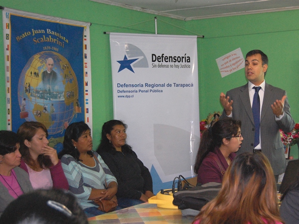 El jefe de Estudios de Tarapacá, Cristian Sleman, durante su charla ante inmigrantes en Iquique.