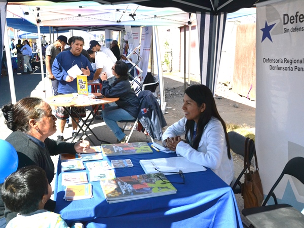 La facilitadora intercultural Andrea Mamani atendiendo a una madre en la plaza de justicia de Alto Hospicio.