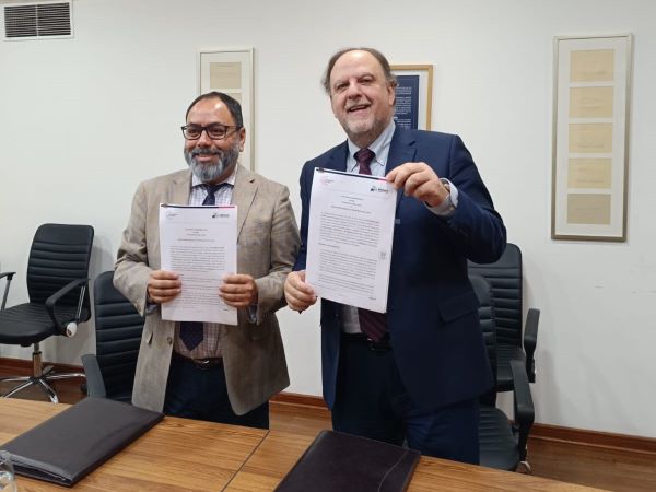 El Defensor Regional (s), Crhistian Basualto, y el rector de la universidad, Rafeal Rossel, tras firmar el convenio interinstitucional.