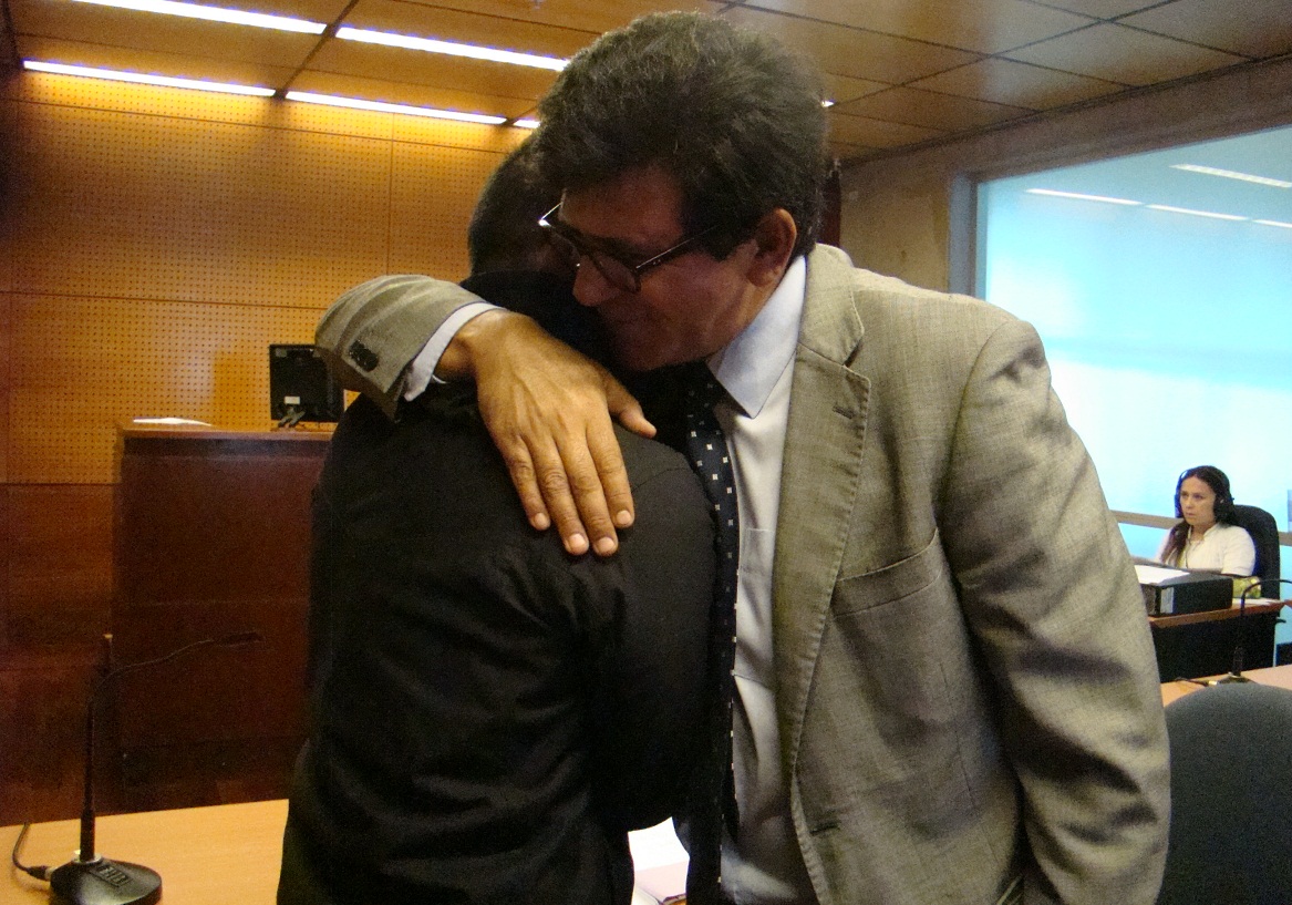 Jorge Aravena abraza a su defensor penitenciario tras el fallo que le permitió quedar en libertad cinco años antes de lo previsto.