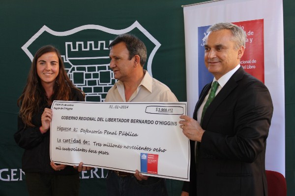 El Defensor Nacional, Georgy Schubert, y el interno Patricio Zúñiga recibieron el cheque con el aporte del FNDR. 