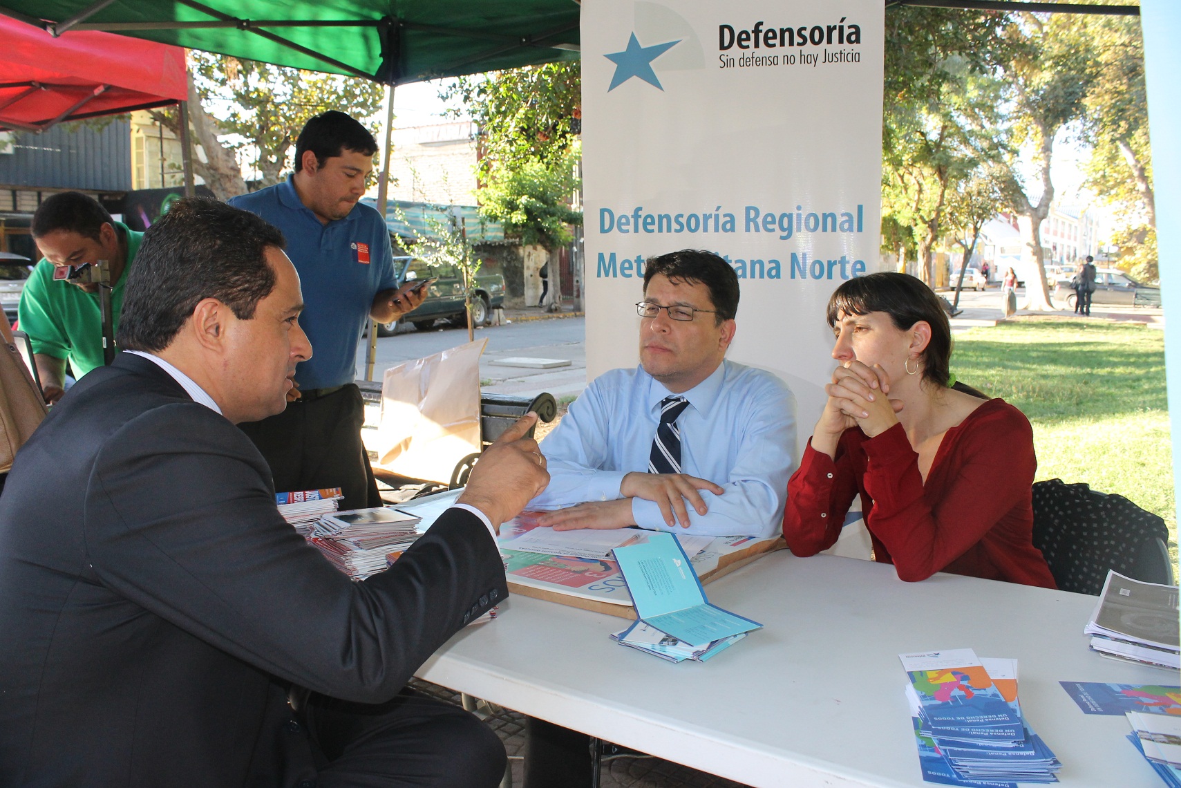 El cónsul peruano José Antonio Torrico conversó con Gabriel Carrión y Francisca Sellés en la plaza de justicia de migrantes.