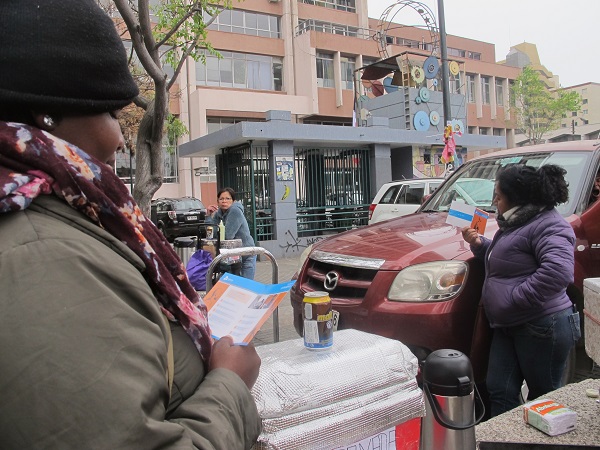En la plaza cívica, los ciudadanos haitianos leen el díptico sobre defensa de extranjeros.