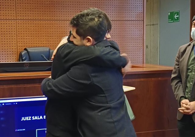 El defensor penal juvenil Joaquín Müller abraza a Isaac durante la ceremonia de egreso del TTD en el Centro de Justicia de Santiago (TTD).