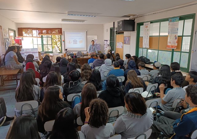 Hombres y mujeres del colegio Miravalle de Peñalolén escuchan atentamente al defensor penal juvenil Joaquín Müller.