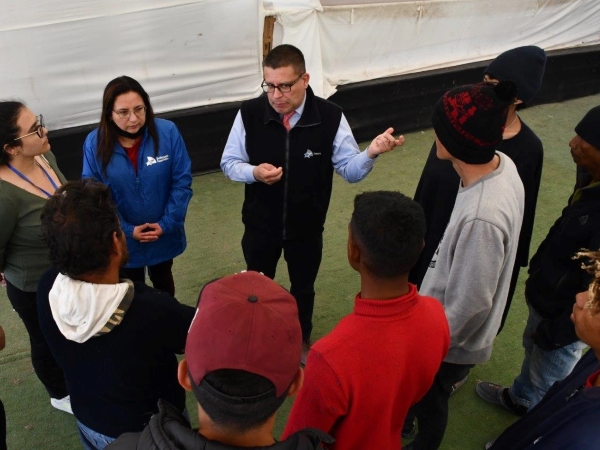 La charla ante el grupo de personas migrantes asentado en el albergue Lobitos, al sur de Iquique.