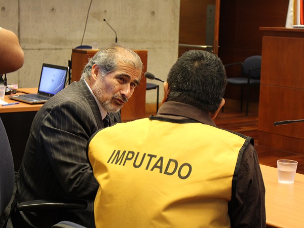 El defensor público Gustavo Valenzuela,conversa con el acusado, previo al verdicto. 