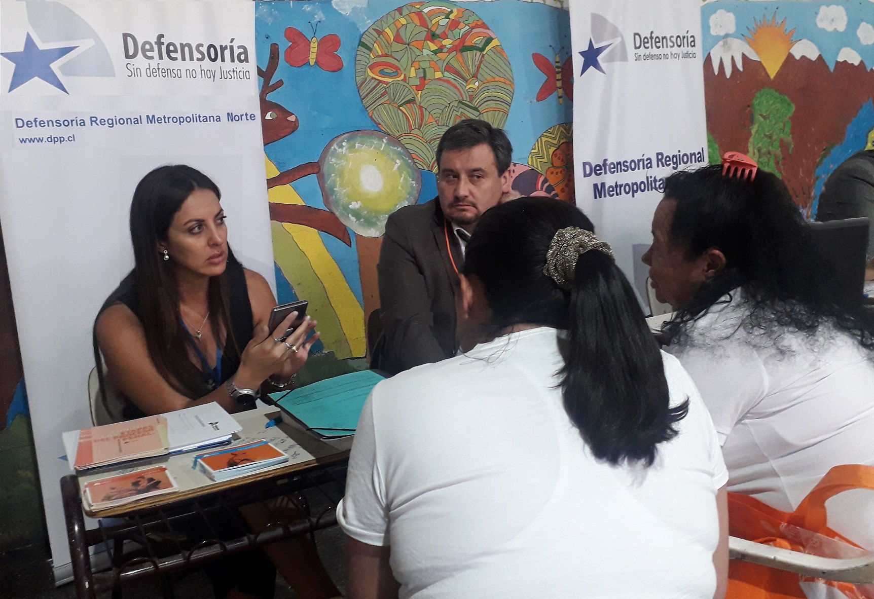 Los defensores públicos Patricia Alvarado y Mauricio Jara explican sus derechos a las imputadas migrantes en prisión preventiva.