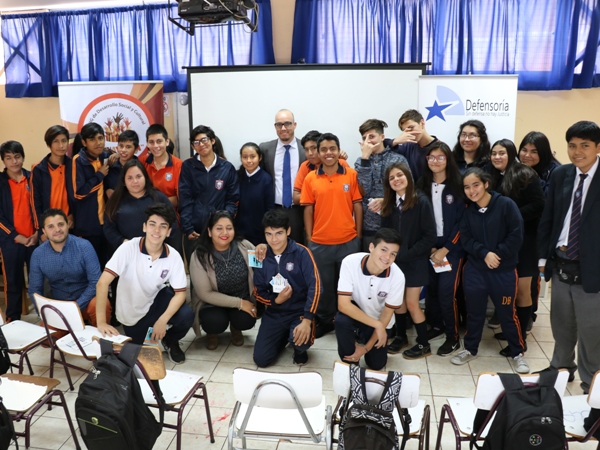 El defensor público Rodrigo Arancibia junto a los alumnos de Colegio "Don Bosco" en Arica y a representantes de la ONG 'Kunaymana'.