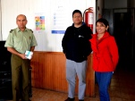 Los representantes de la Defensoría de Tarapacá y el jefe del Retén de Carabineros de Quillagua, luego de colocar los afiches sobre derechos de los im