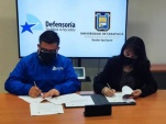 El Defensor Regional y la Directora de la sede Iquique de la Universidad de Tarapacá estampan sus firmas en el convenio.