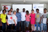 La defensora Pamela Urquhat juntoa alas voluntarias de la Cruz Roja y los haitianos que participaron de la actividad