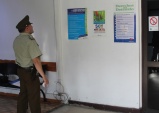Carabinero de turno en la Cuarta Comisaría de Santiago observa los afiches instalados por la DRMN sobre los Derechos del Detenido